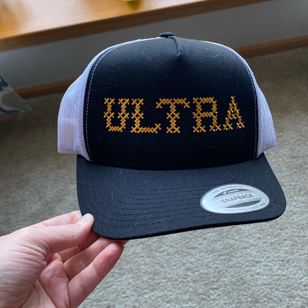 Ultra trucker hat. Black with yellow cross stitch